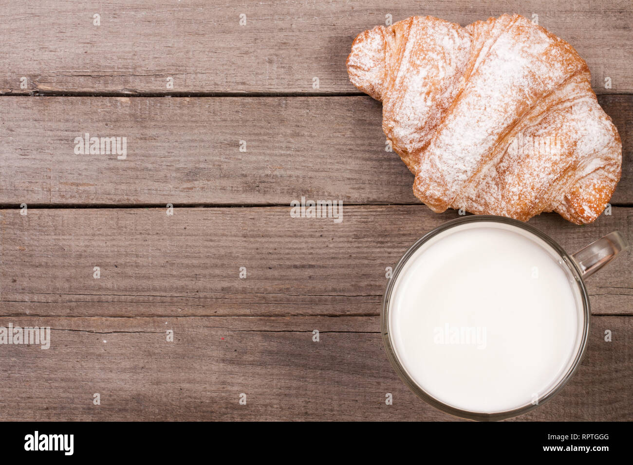 Glas Milch mit Croissants von alten hölzernen Hintergrund mit Kopie Platz für Ihren Text. Ansicht von oben Stockfoto