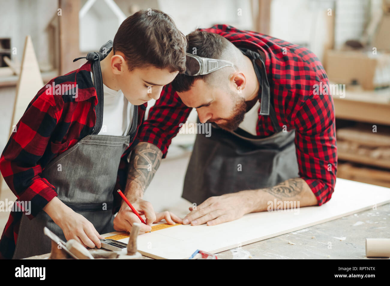 Neugierige kleine Junge Klassen der Tischlerei aus berühmten WOODWORKER. Hobby wächst in der Arbeit von Berufung. Stockfoto