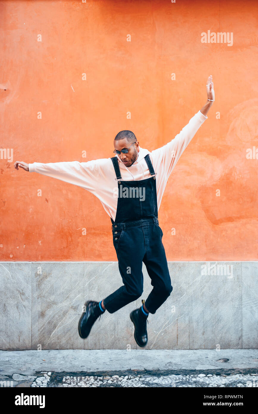 Junge schwarze Mann legere Kleidung springen im Freien Stockfoto