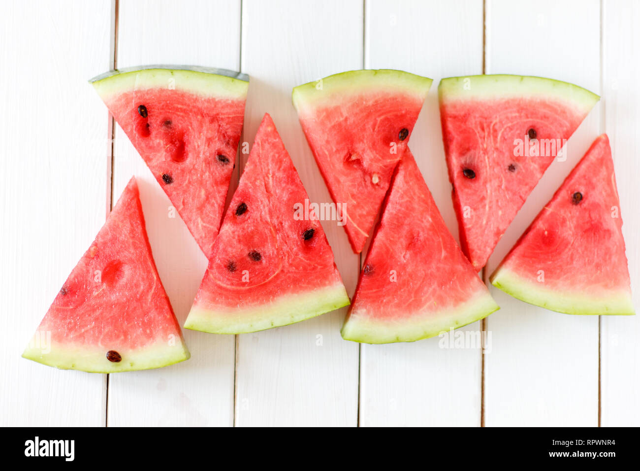 Wassermelone Schicht auf einem weißen rustikal Holz Hintergrund, beliebt im Sommer Obst mit lecker Wassermelone, Flach Fotografie der Wassermelone Schicht Eis am Stiel. Stockfoto