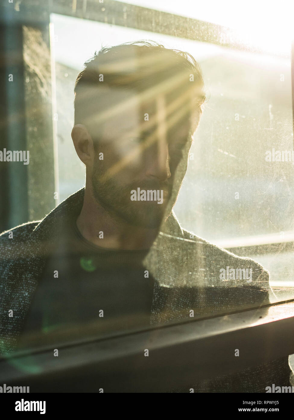 Ein stattlicher Mann hinter Glas im Freien in Telefonzelle Stockfoto