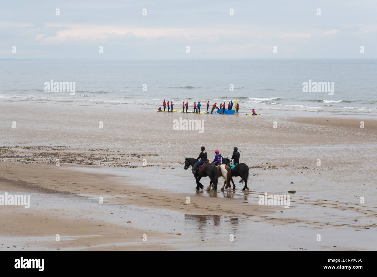 Reiter und Surfschule am Strand von Saltburn-by-the-Sea, North Yorkshire, England. Stockfoto