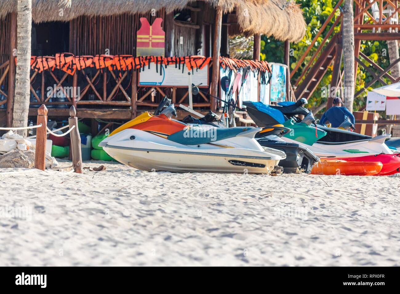 Reihe von Jet Ski an einem wunderschönen weißen karibischen Sandstrand an der Riviera Maya, Mexiko neben einem Surf Shack zu mieten. Stockfoto