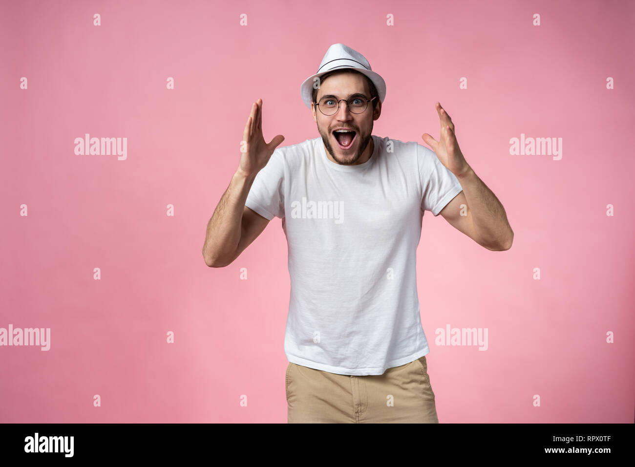 Expressive glücklich überrascht Mann, isoliert auf Rosa. Stockfoto