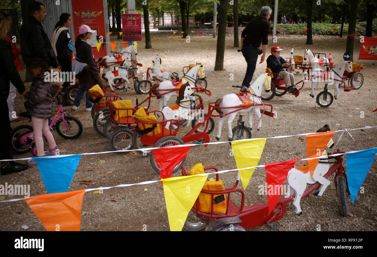 Kinderfahrräder hölzerne Pferde in einem Pariser öffentlichen Garten - PARIS SPIELE FÜR KINDER - PARISER KINDER - alte Zeit Spiele - PARIS - RETRO VINTAGE SPIELE KINDER SPIELE - CHEVAUX DE BOIS À PÉDALES NOSTALGISCHE ZEIT - FARBE ARCHIV FOTOGRAFIE © Frédéric BEAUMONT Stockfoto