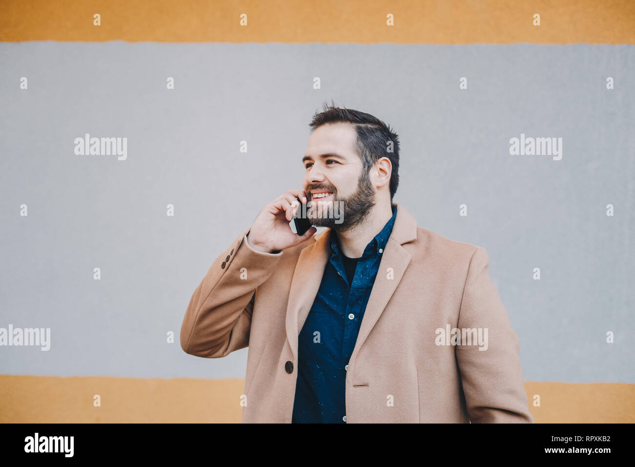Close-up Portrait von attraktiven, modernen jungen Mann in einem Handy Gespräch, in modischer Kleidung posiert vor einem bunten backgro Stockfoto