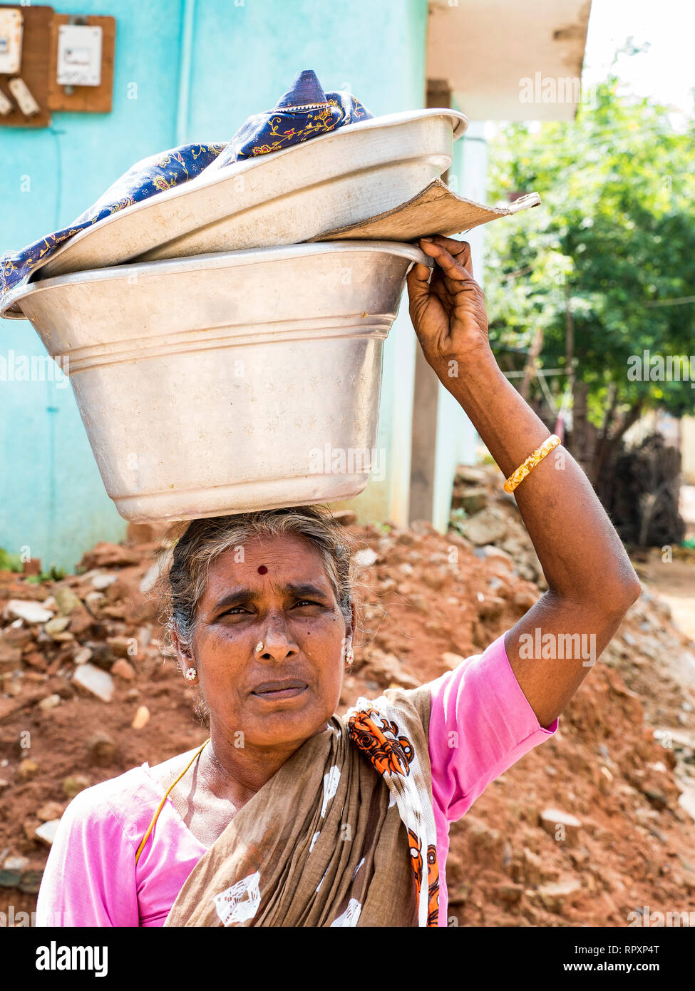 PUDUCHERY, INDIEN DEZEMBER Circa, 2018. Nicht identifizierte Frau mit Geernteten yam in eine Schüssel auf dem Kopf. Die Armut im indischen Dorf, mit schweren Trauriges Gesicht Stockfoto