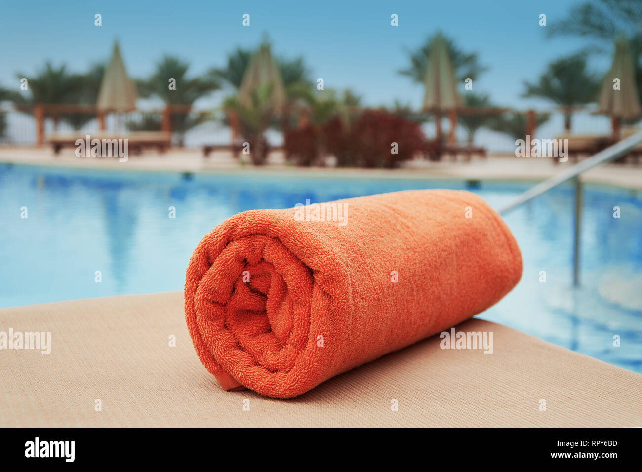 Orange Handtuch liegen auf einer Liege in der Nähe des Swimming pool Sommer Stockfoto Orange Handtuch liegen auf einer Liege in der Nähe des Swimming pool Sommer Stockfoto