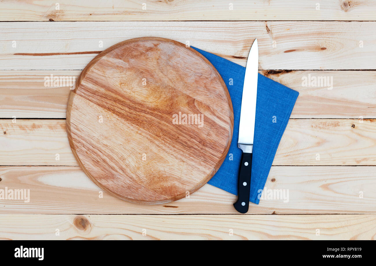 Runde Schneidebrett mit Messer auf einem Holztisch, Ansicht von oben Stockfoto