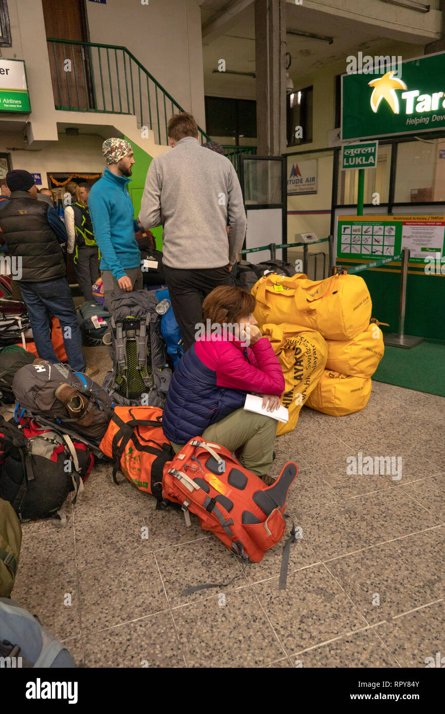 Nepal, Kathmandu Tribhuvan International Airport, inländischen Abflugbereich, Passagiere saßen auf Gepäck warten auf verspätete Flüge nach Lukla Stockfoto