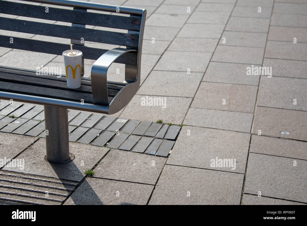 Stratford-upon-Avon, Warwickshire, England UK 22. Februar 2019 Kunststoff Mcdonalds Cup auf der Parkbank mit Platz für Überschrift Stockfoto