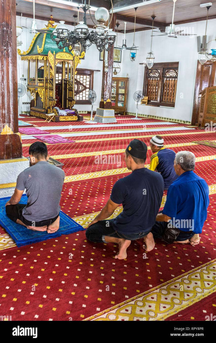 Junge Männer beten im Gebetsraum der Moschee Masjid Hulu Hulu, Melaka, Malaysia. Stockfoto