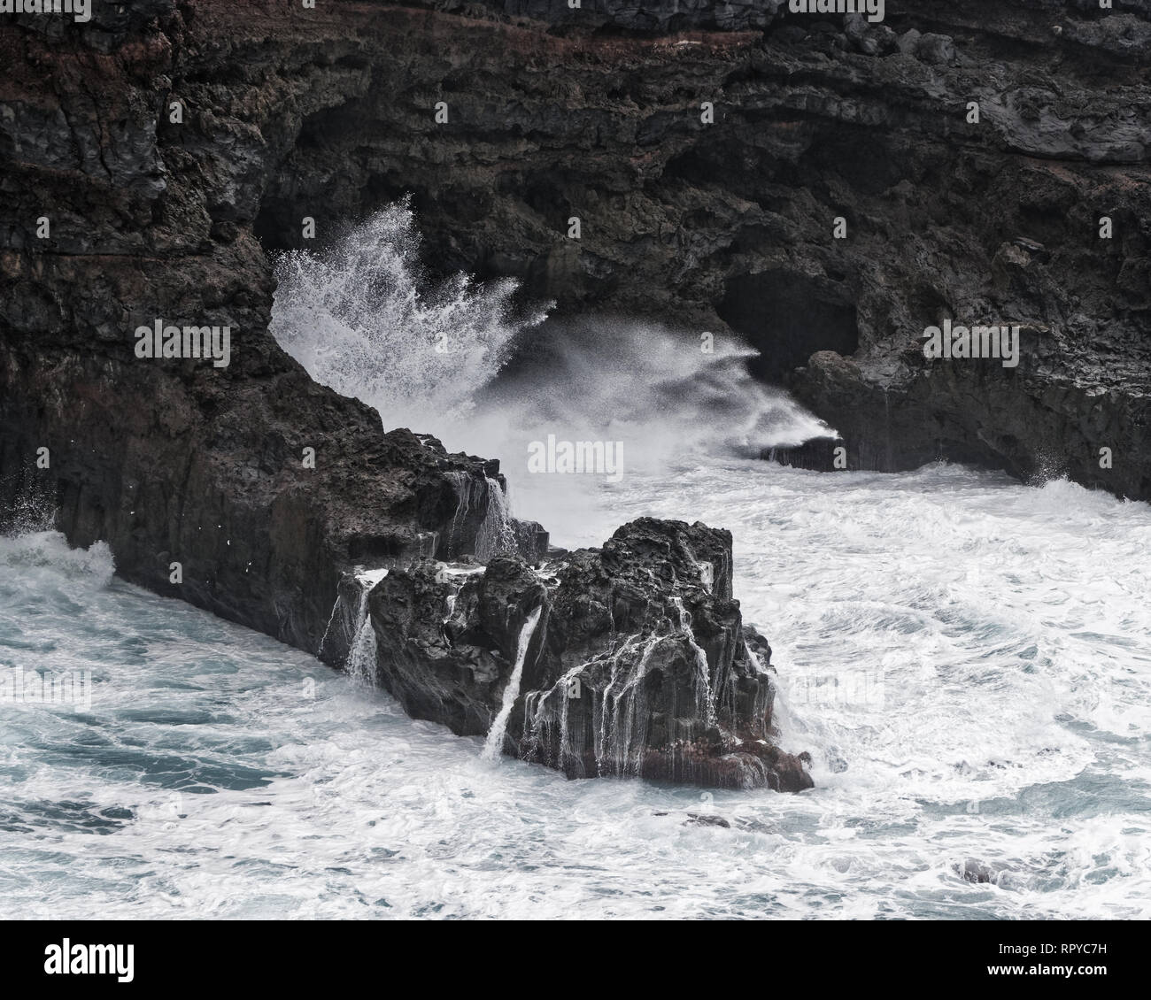 Eine Welle stürzt bei stürmischem Wetter auf einer felsigen Küste, Gischt spritzt, Wasser Bewegung in lange Belichtung, Detail - Ort: Spanien, Kanarische Inseln, La Palma Stockfoto