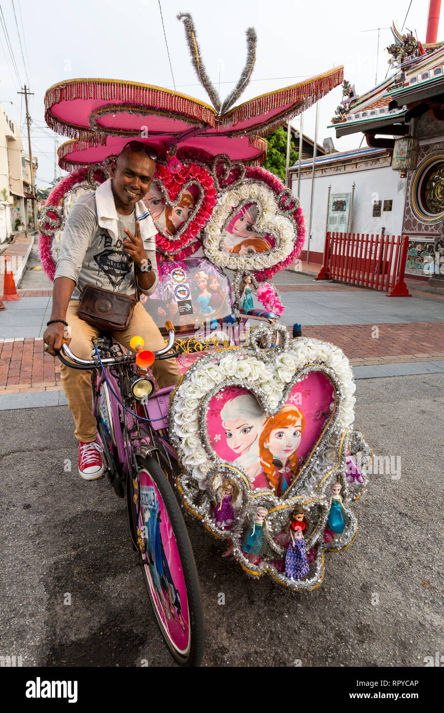 Malaysische Fahrer mit seinem Trishaw, beliebt bei Touristen als Alternative zu Wandern. Melaka, Malaysia. Stockfoto