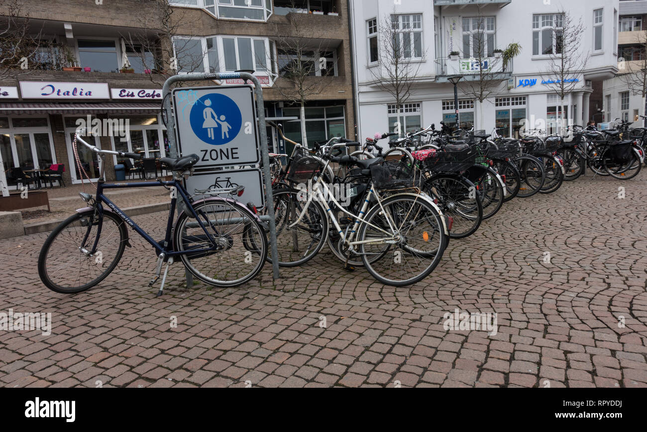 Große Gruppe von Fahrrädern auf Kopfsteinpflaster geparkt. Oldenburg. Niedersachsen. Deutschland. Stockfoto