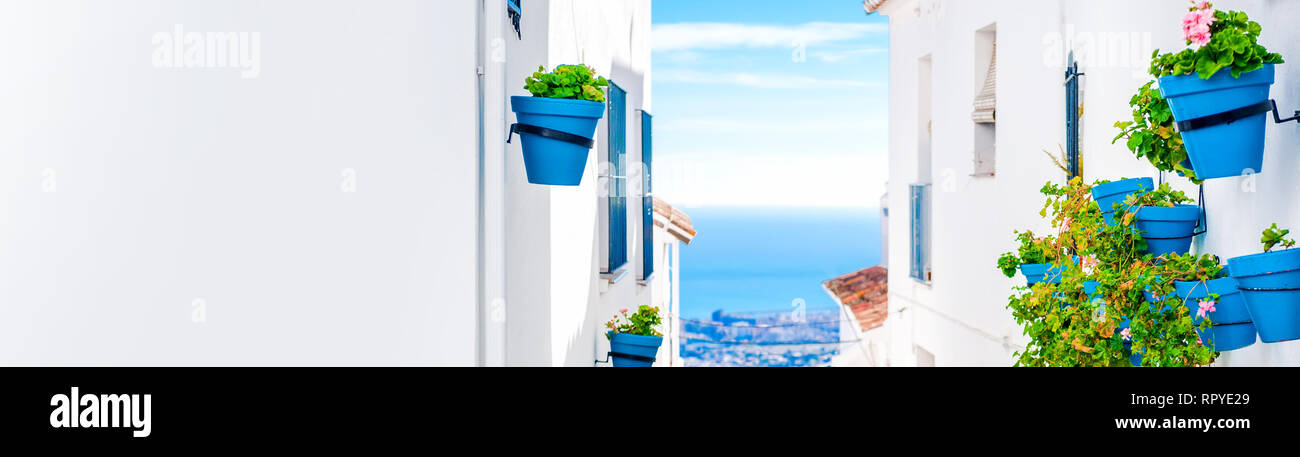 Malerische Gasse von Mijas mit blau Blumentöpfe am Hang Häuserfassaden Mittelmeer. Andalusischen weißen Dörfer. Costa del Sol Spanien, Stockfoto