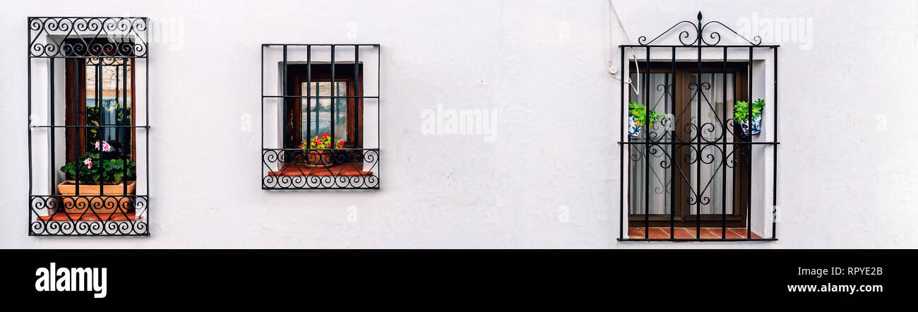 Drei geschlossene Fenster mit Gitter aus Stahl auf einem weiß getünchten Wand in einer Reihe im Freien anzeigen. Andalusischen weissen Dorf Mijas. Costa del Sol. Europa, Süd Stockfoto