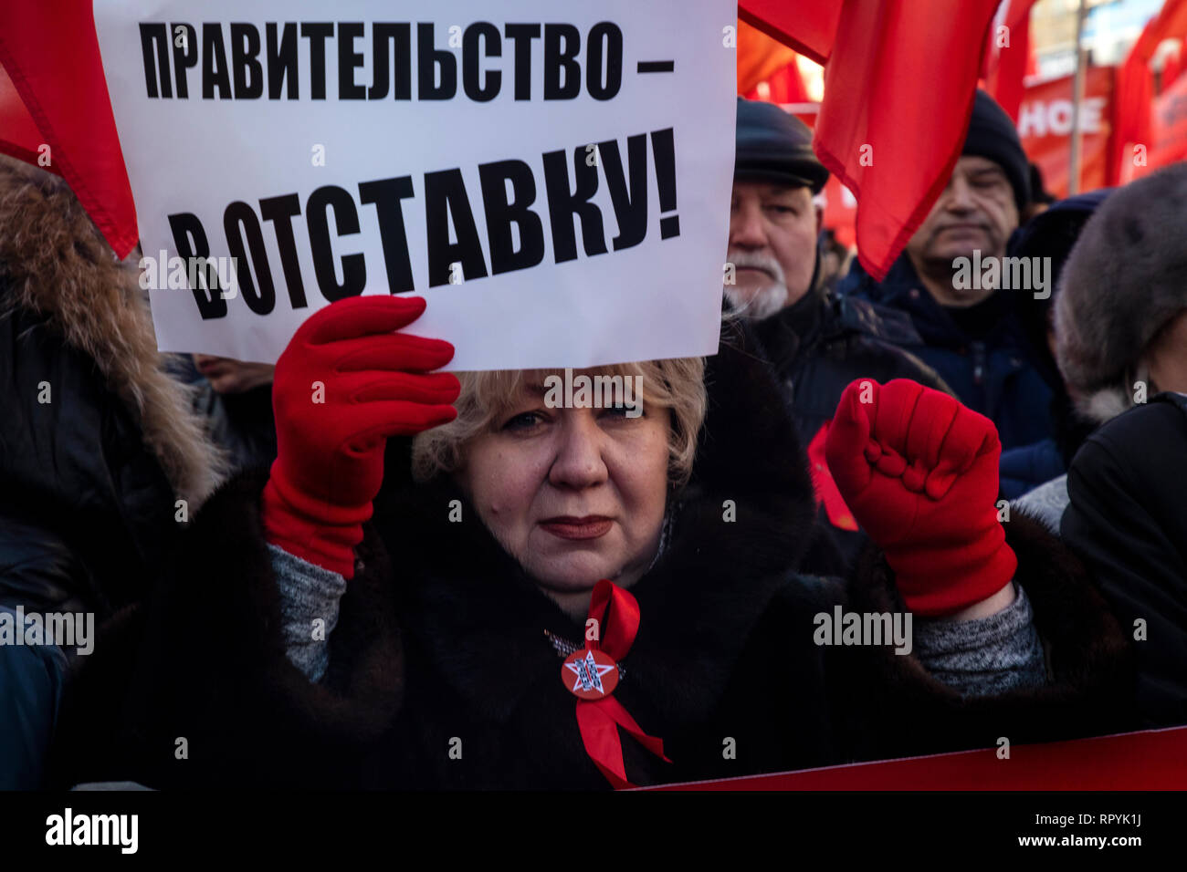 Moskau, Russland. 23. Februar 2019: einer Frau mit einem Banner mit der Aufschrift "die Regierung zum Rücktritt" während einer März von der Russischen Kommunistischen Partei im Zentrum von Moskau statt der 101. Jahrestag der Errichtung der Roten Armee und Marine auf Verteidiger des Vaterlandes Tag Credit: Nikolay Winokurow/Alamy Leben Nachrichten zu markieren Stockfoto