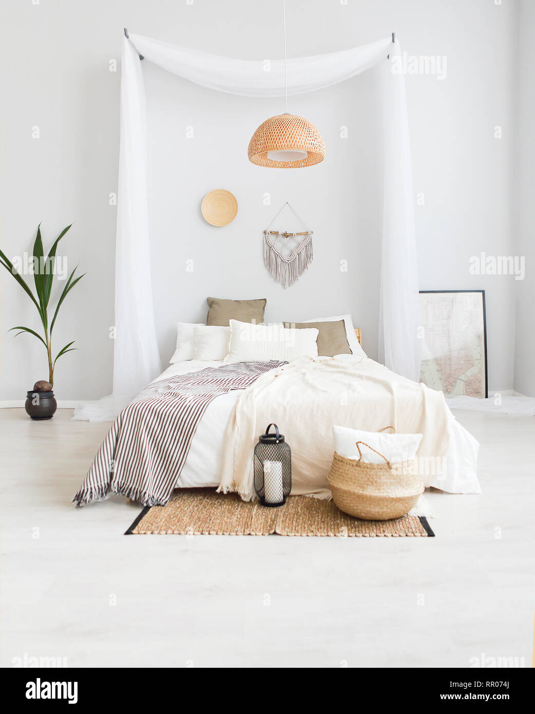 Weiß und Beige Schlafzimmer in boho Style mit macrame an der Wand Stockfoto