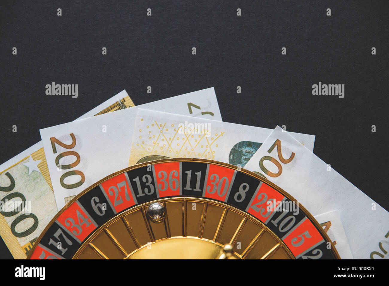 Gold casino Thema. Bild von casino Roulette, Poker Spiele, Geld auf den Tisch und alle auf einem dunklen bokeh Hintergrund. Für den Druck und das Logo. Stockfoto