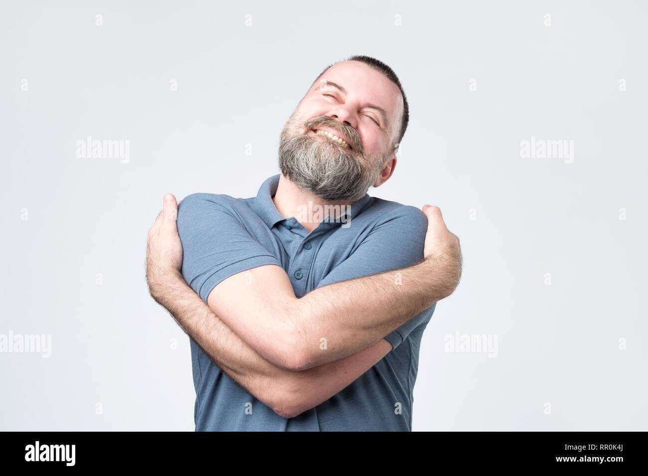 Lustige egoistisch reifen europäischen Kerl im blauen Hemd kuscheln sich Stockfoto