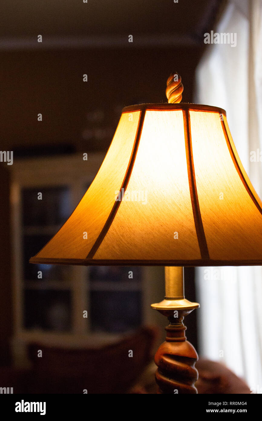 Beleuchtete Lampe mit Schatten in einem schwach beleuchteten Zimmer Stockfoto