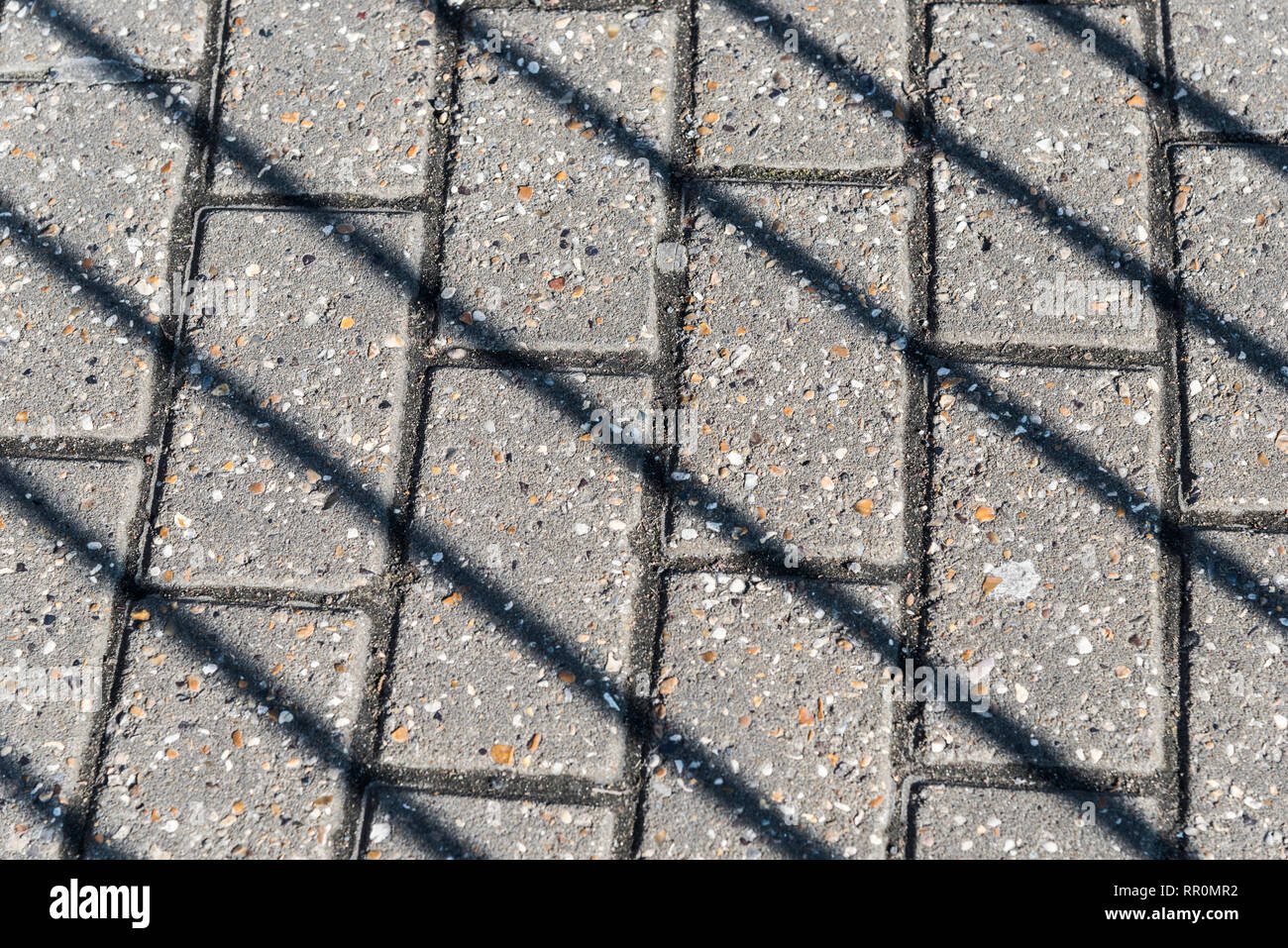 Diagonale Schatten der Geländer auf dem Bürgersteig an einem sonnigen Februartag in London, Vereinigtes Königreich Stockfoto