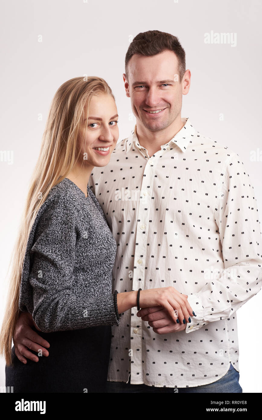 Lächelnden jungen kaukasischen Paar stehend in Studio Light isoliert Stockfoto