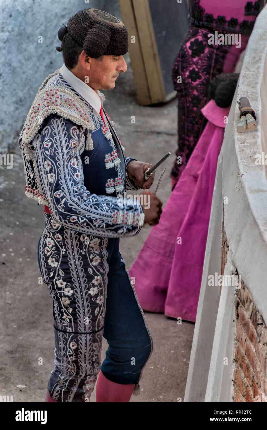 SAN MIGUEL DE Allende, Mexiko - ein Matador schärft sein Messer, bevor sie in den Ring zu kämpfen. Im Profil gesehen, der Matador ist in vollem Kostüm. Stockfoto