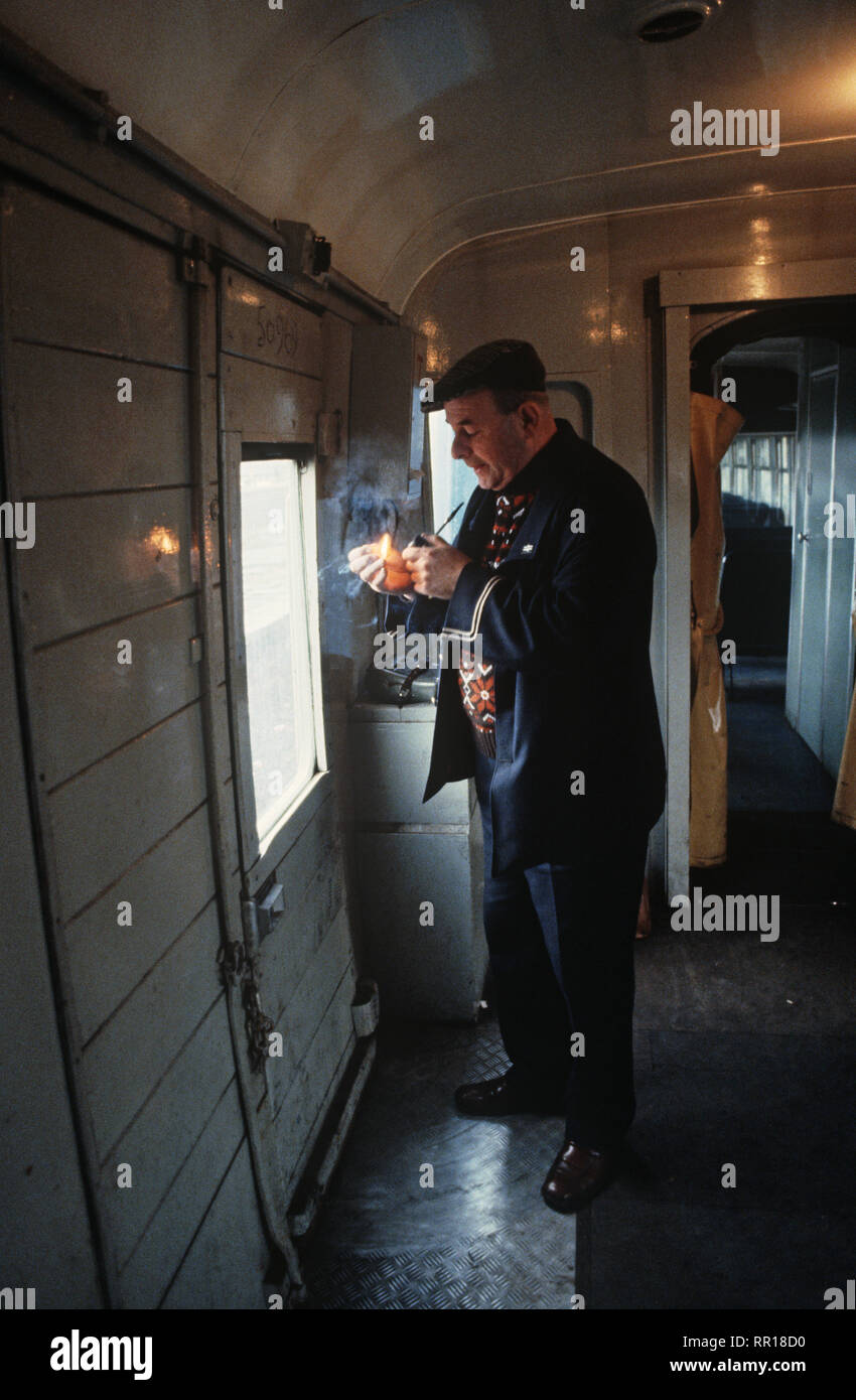 British Rail guard rauchen Rohr in Zug wachen van auf Oxenholme nach Windermere, Lake District, England Stockfoto