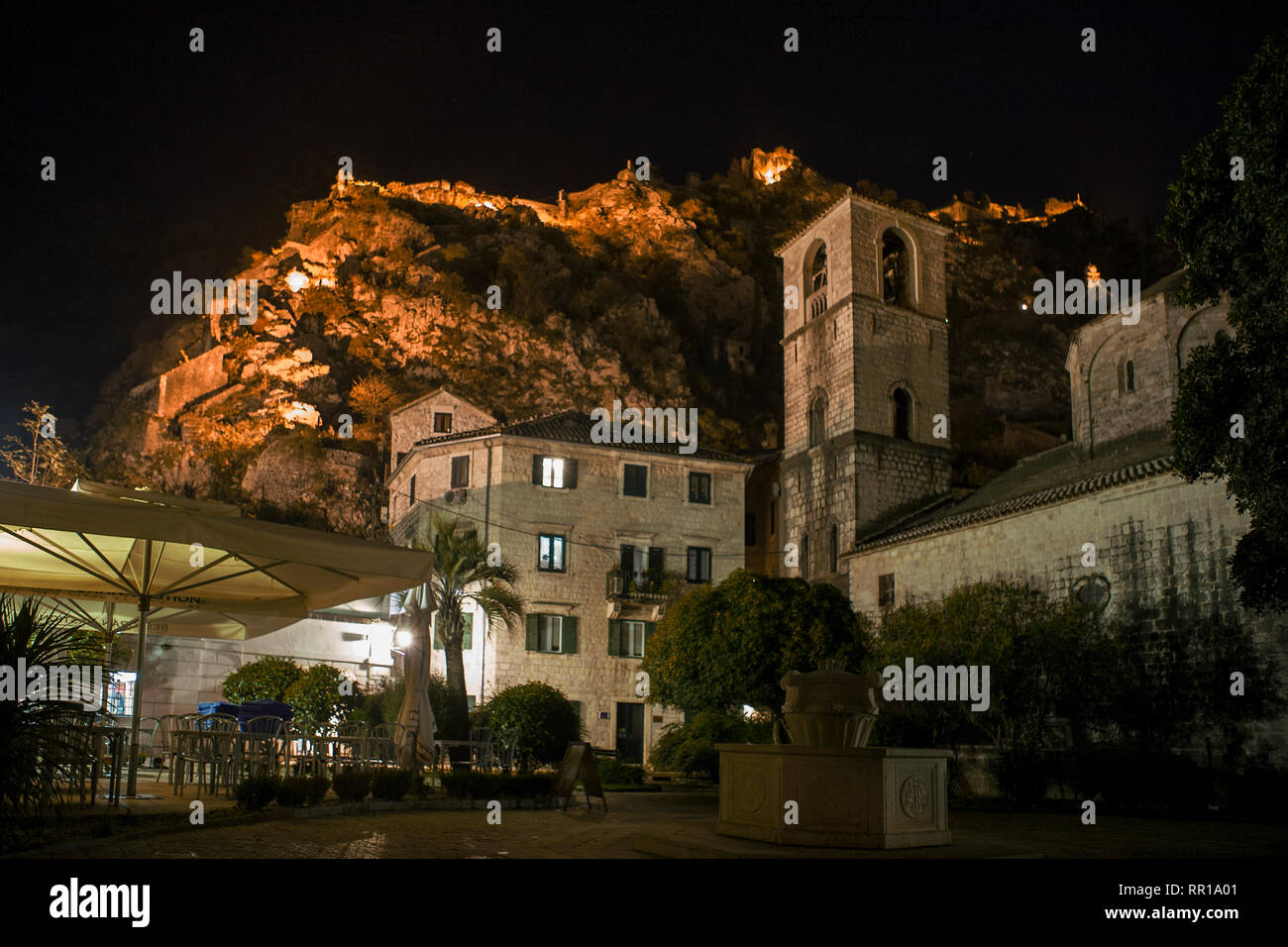 Trg od Drva (Holz), St. Mary's Stiftskirche und die Stadtbefestigung oben beleuchtet bei Nacht: Kotor, Montenegro Stockfoto