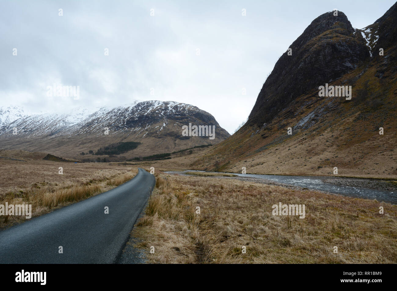 Eine Straße entlang des Flusses Etive unter den Bergen des Glen Etive Tal im frühen Frühjahr, Western Highlands, Schottland, Großbritannien. Stockfoto