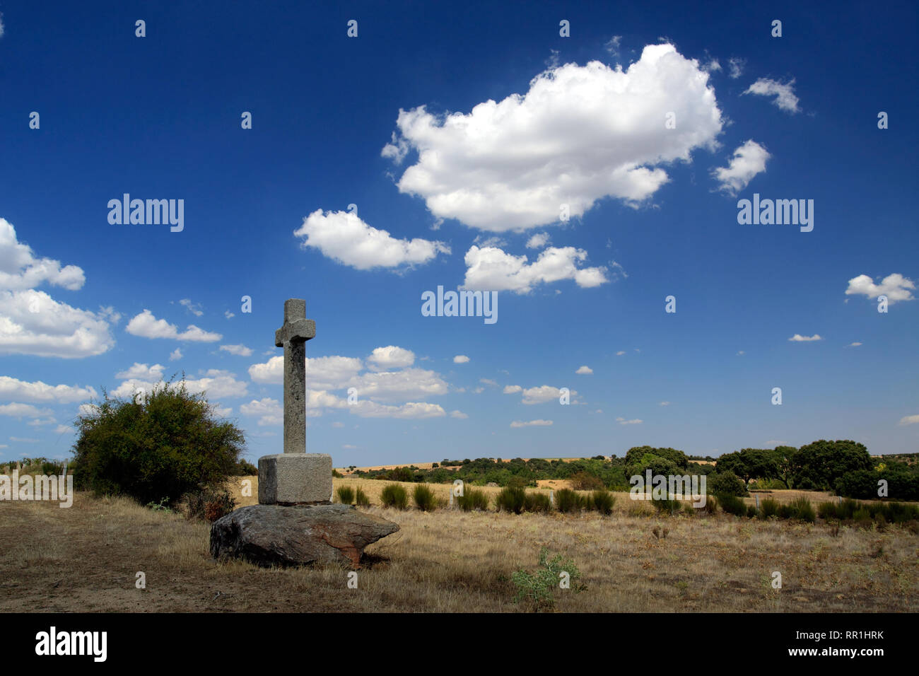 Typische Landschaft des nordöstlichen Portugiesisch mit einem Kreuz in der Mitte der Ebene gegen den tiefblauen Himmel und weißen Wolken Stockfoto