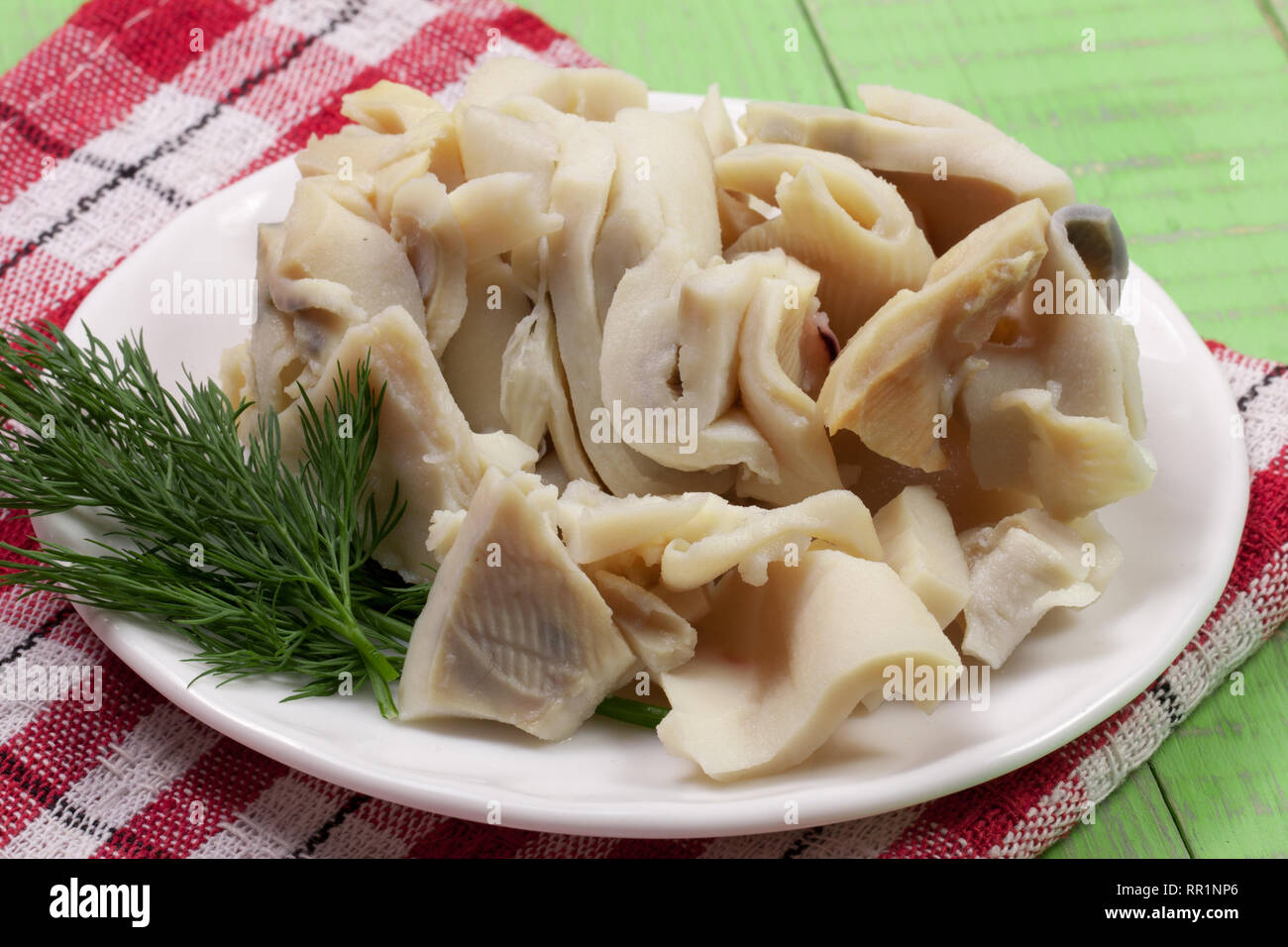 In Scheiben geschnitten Kalmar auf einer Platte auf einem grünen Holz- Hintergrund Stockfoto