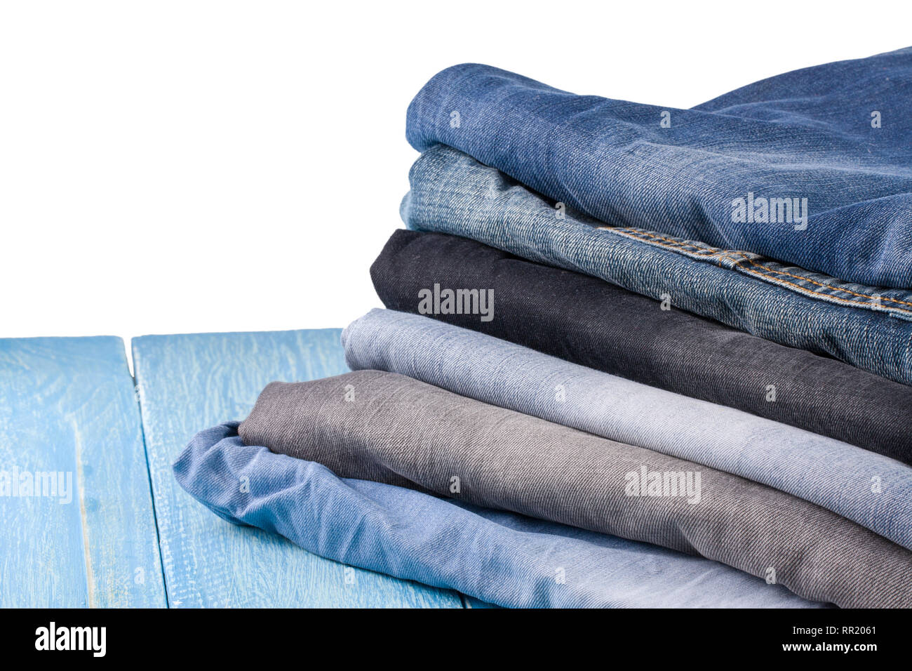 Stapel von Jeans auf Blau Holz- Hintergrund Stockfoto