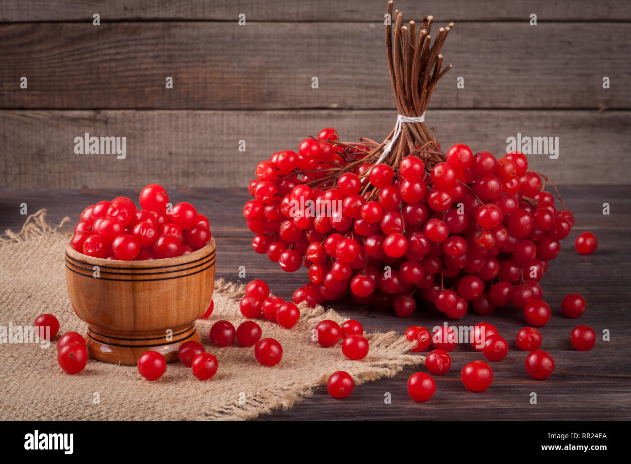 Reife rote viburnum Beeren in eine Schüssel auf hölzernen Hintergrund Stockfoto