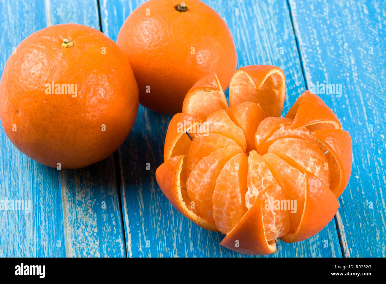 Drei tangerine auf einem blauen Hintergrund aus Holz Stockfoto