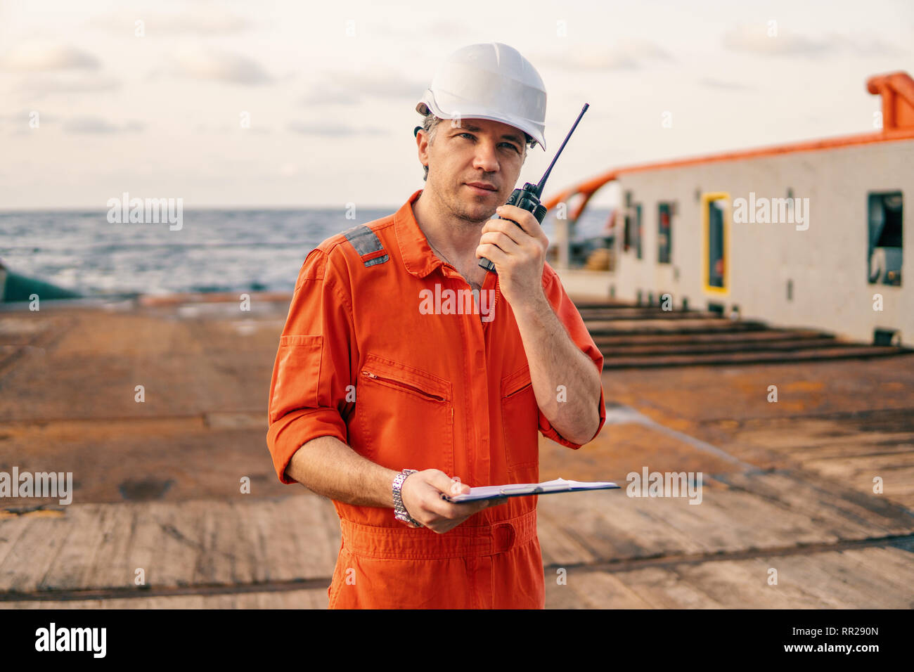 Deck Officer an Deck von offshore Schiff hält VHF-Funkgerät, Radio Stockfoto