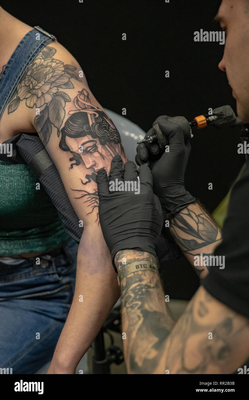 Brighton, UK. 23 Feb, 2019. Tattoo Künstler arbeitet auf einem Client am 12. jährlichen Brighton Tattoo Convention am Brighton Centre, England. Credit: Jason Richardson/Alamy leben Nachrichten Stockfoto