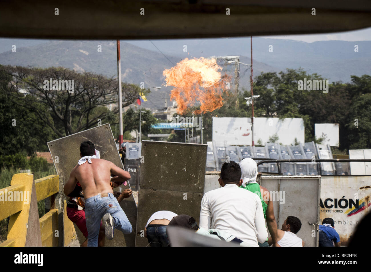 Caracas, Venezuela. 23 Feb, 2019. Die Demonstranten werfen Steine bei Zusammenstößen mit den Sicherheitskräften an der Francisco de Paula Santander internationale Brücke Brücke zwischen Cucuta, Kolumbien, und Urena, Venezuela, bei dem Versuch, die humanitäre Hilfe über die Grenze nach Venezuela zu überqueren. Uns - gespendete humanitäre Hilfe wurde ''Auf dem Weg'' nach Venezuela, Oppositionsführer Juan Gauido verkündete Samstag, als er eine Verteilung mit den Präsidenten von Kolumbien, Chile und Paraguay ins Leben gerufen. Credit: Elyxandro Cegarra/ZUMA Draht/Alamy leben Nachrichten Stockfoto