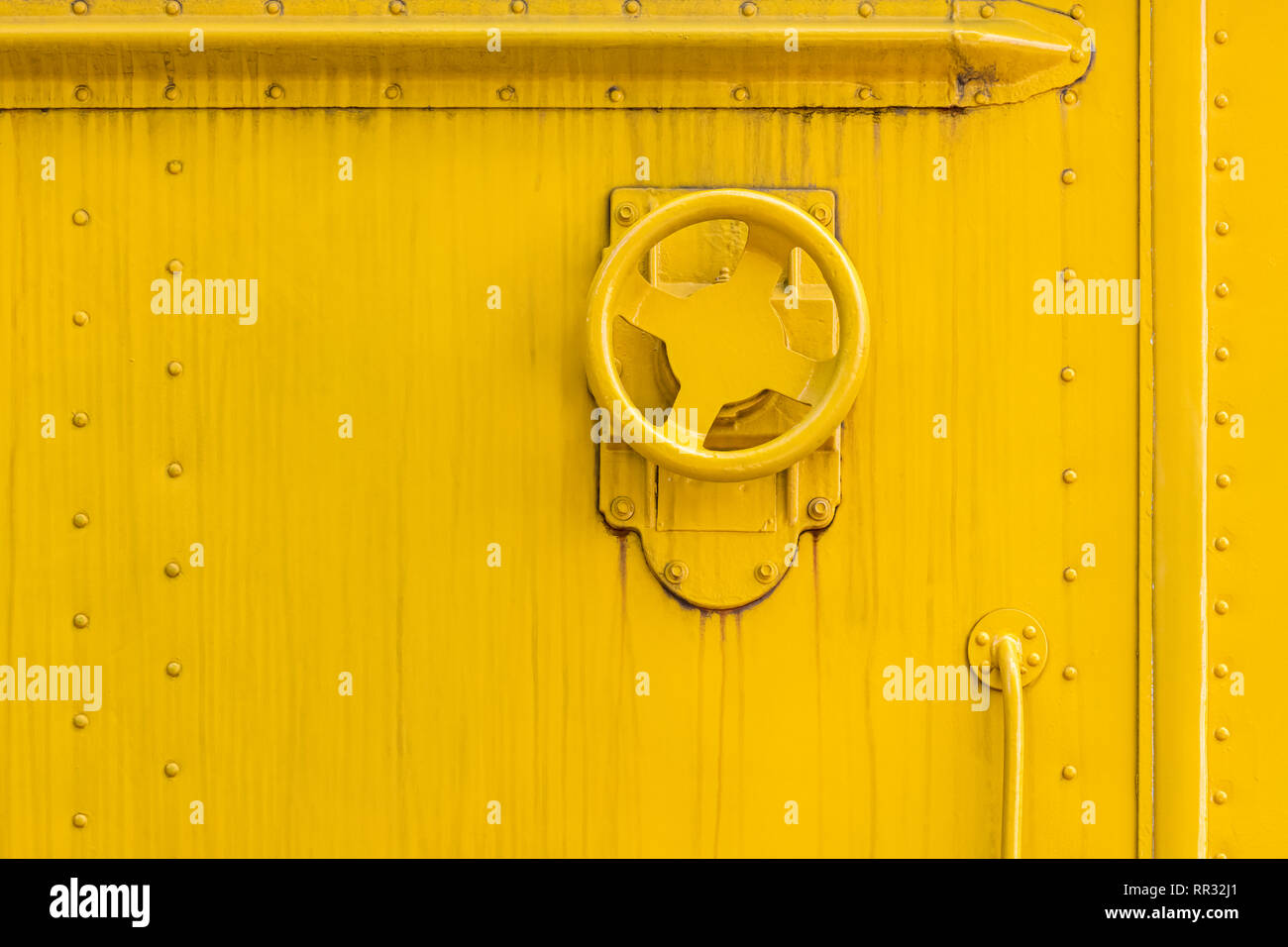 Industrielle Ventil Rad auf Gelb lackiertem Metall wand Oberfläche. grunge verwitterten Hintergrund Stockfoto