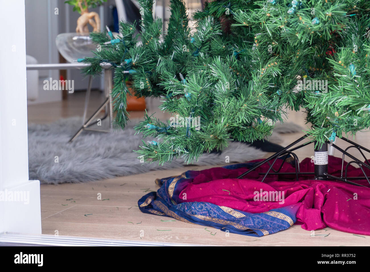 Unten auf einen künstlichen Weihnachtsbaum, auf einem Stand in ein Wohnzimmer eingerichtet, bereit, mit Ornamenten verziert, aber leer. Stockfoto