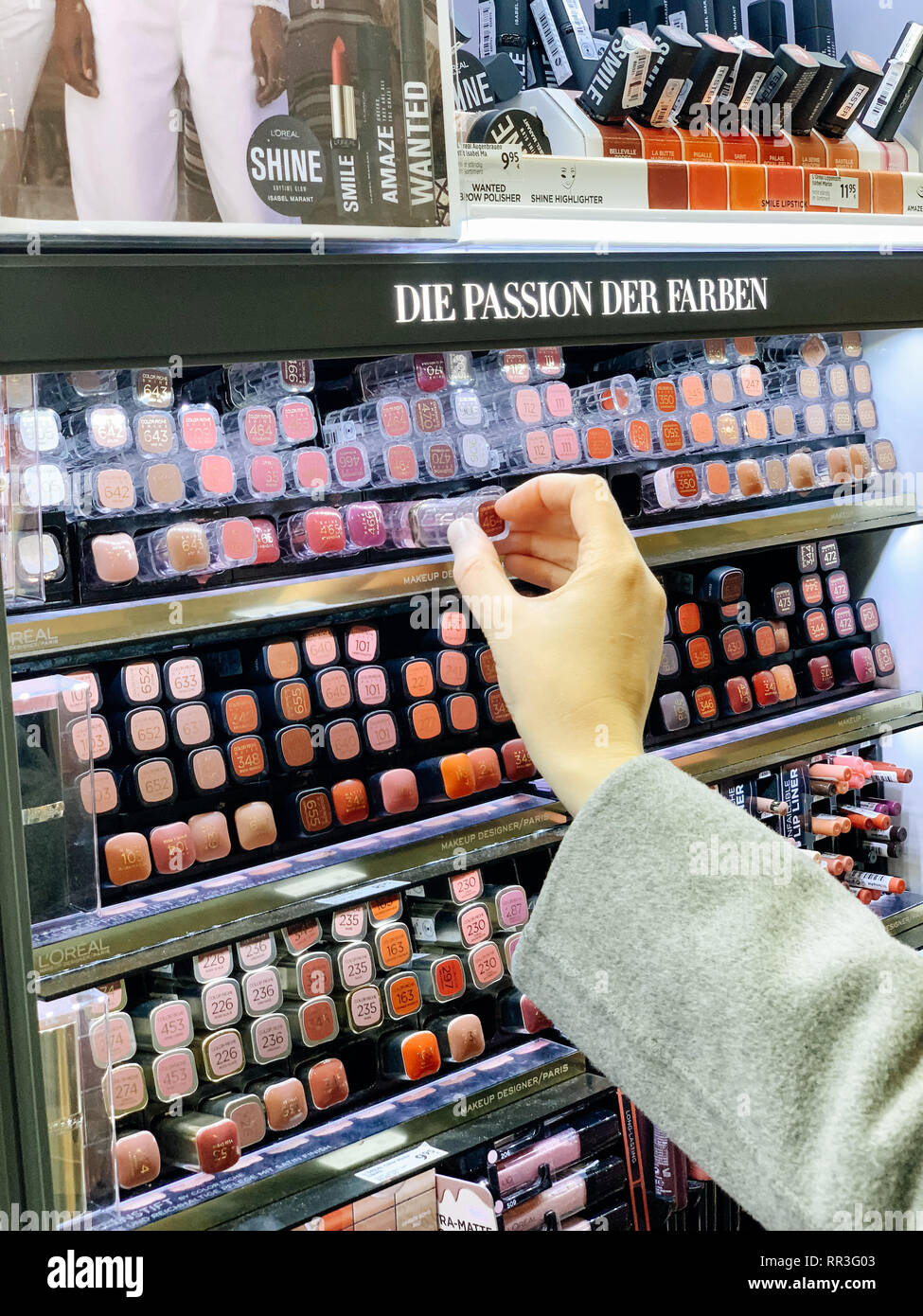 München, Deutschland - 27.Oktober 2018: die Frau in der Kosmetik kaufen Store roten Lippenstift liner crayon von l'Oreal zwischen der Vielzahl von unterschiedlichen Marken Stockfoto