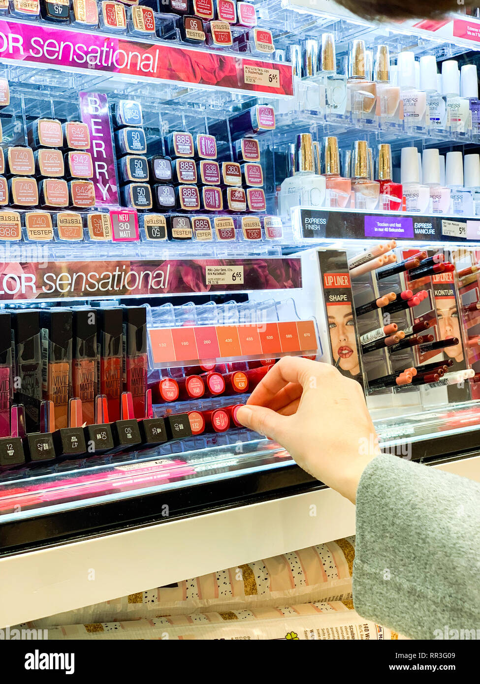 München, Deutschland - 27.Oktober 2018: die Frau in der Kosmetik kaufen Red store Lippenstift liner zeichenstift zwischen der Vielzahl Wahl von l'Oreal Marke Stockfoto