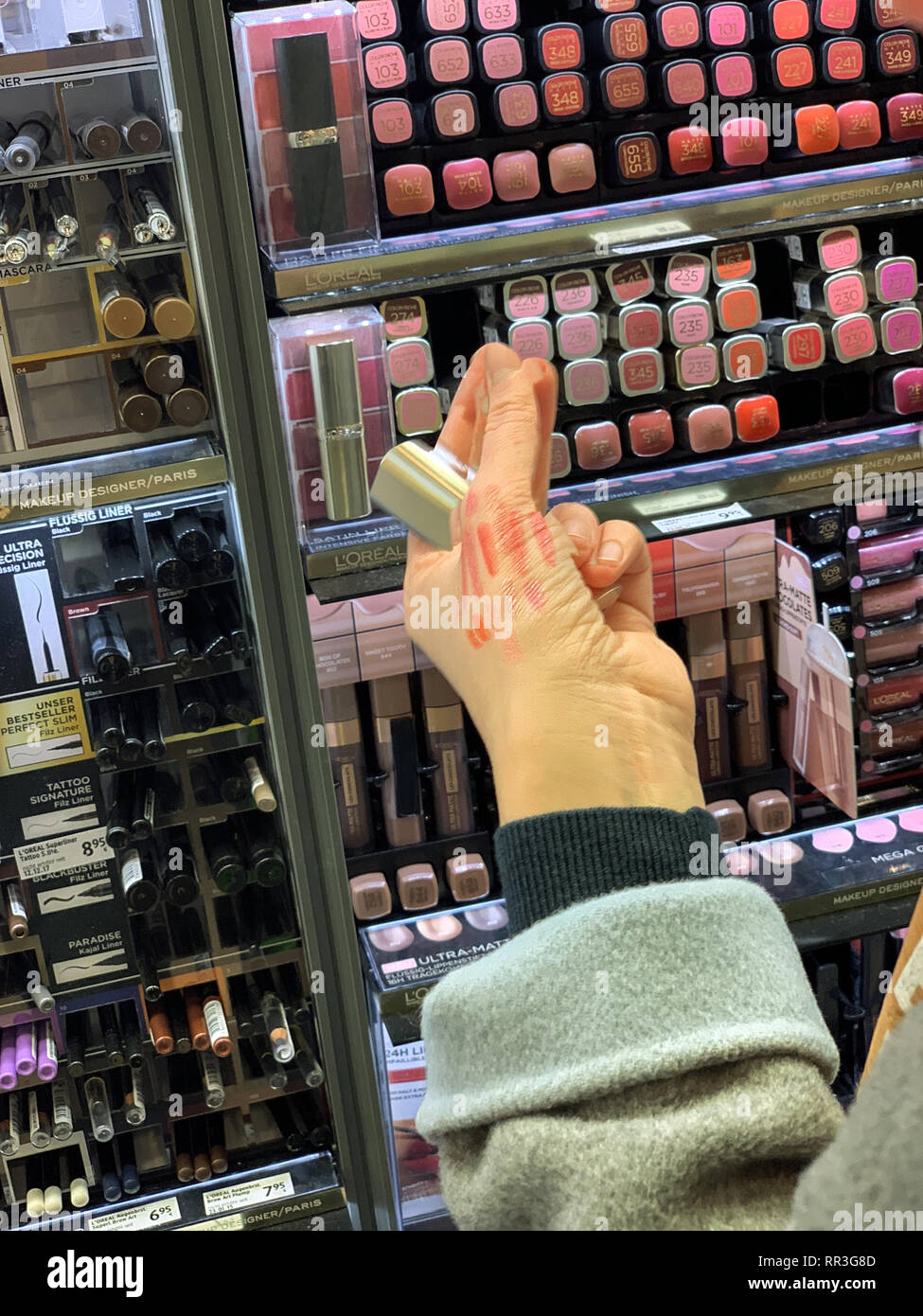München, Deutschland - 27.Oktober 2018: die Frau in der Kosmetik kaufen Red store Lippenstift liner zeichenstift zwischen der Vielzahl von unterschiedlichen Marken, der das Objekt aus den Regalen Stockfoto