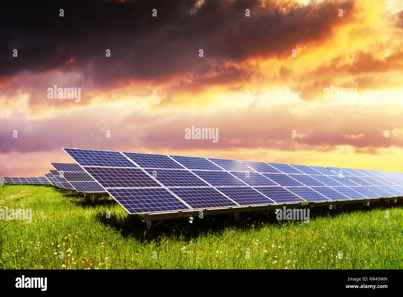 Solar Panel auf und blauer Himmel. Grünes Gras und bewölkter Himmel. Alternative Energie Konzept Stockfoto