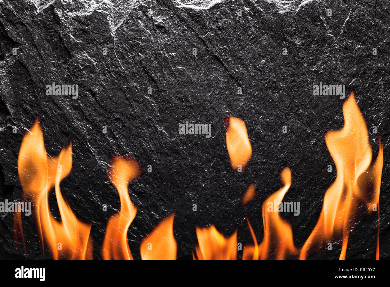 Schwarzer Schiefer mit Feuer Nahaufnahme. Kann wie essen Hintergrund verwendet werden Stockfoto