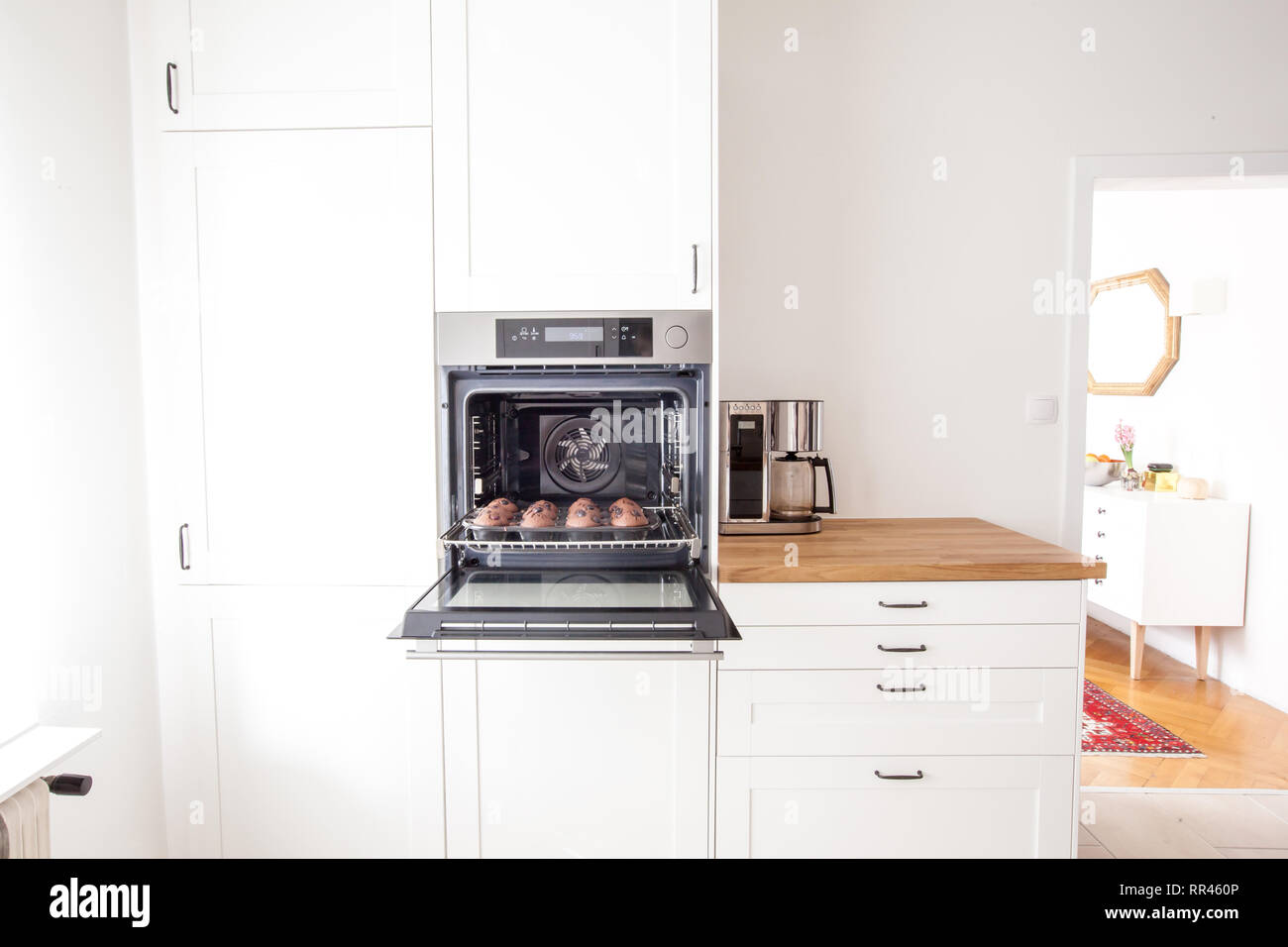 Muffins auf einem Backblech in den Backofen in einem hellen weißen Küche im modernen Landhausstil Stockfoto