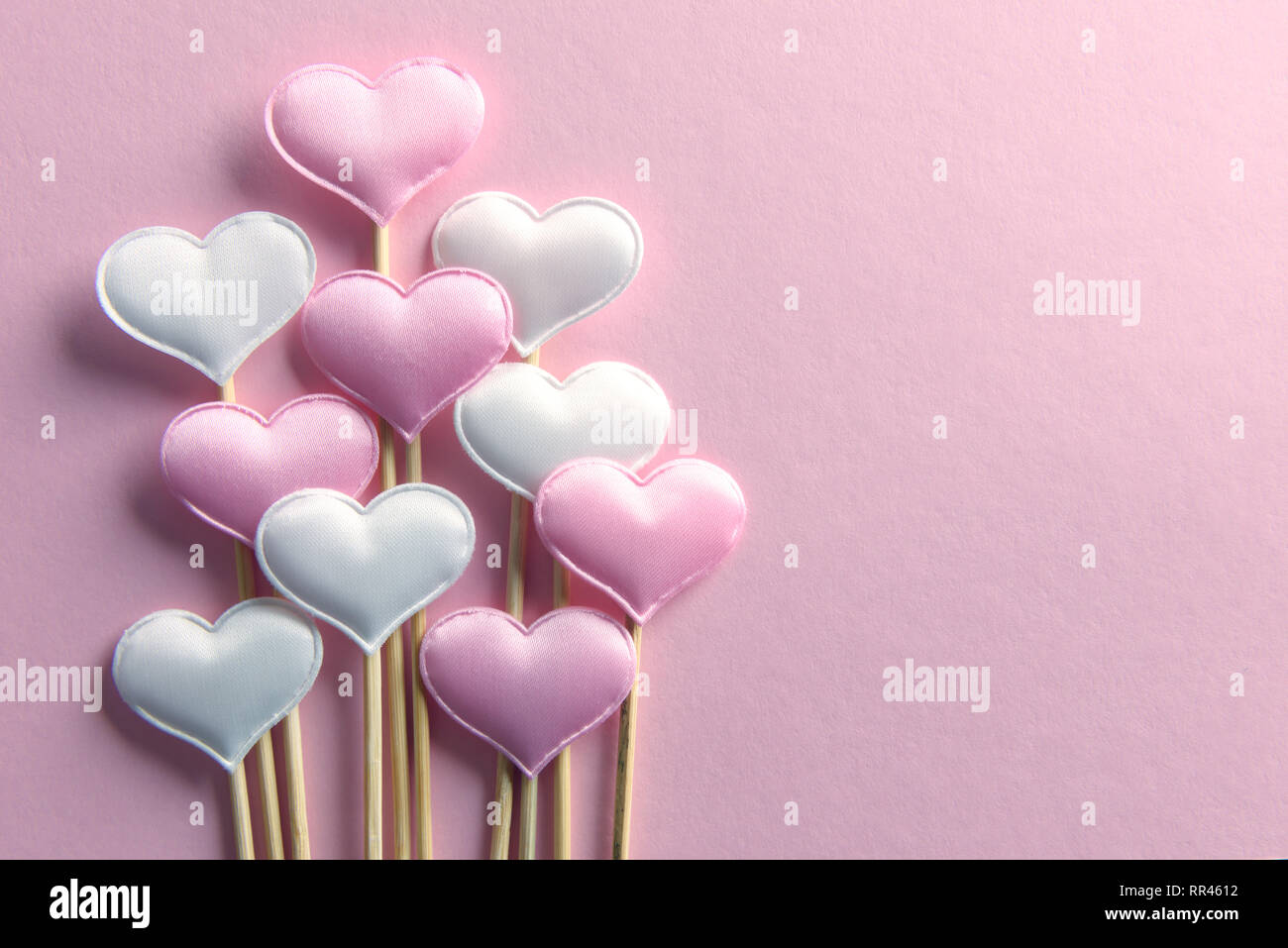 Rosa textile Herzen auf Holzstäbchen Nahaufnahme. Valentines Tag Hintergrund, kreative Textur und liebe Konzept Stockfoto