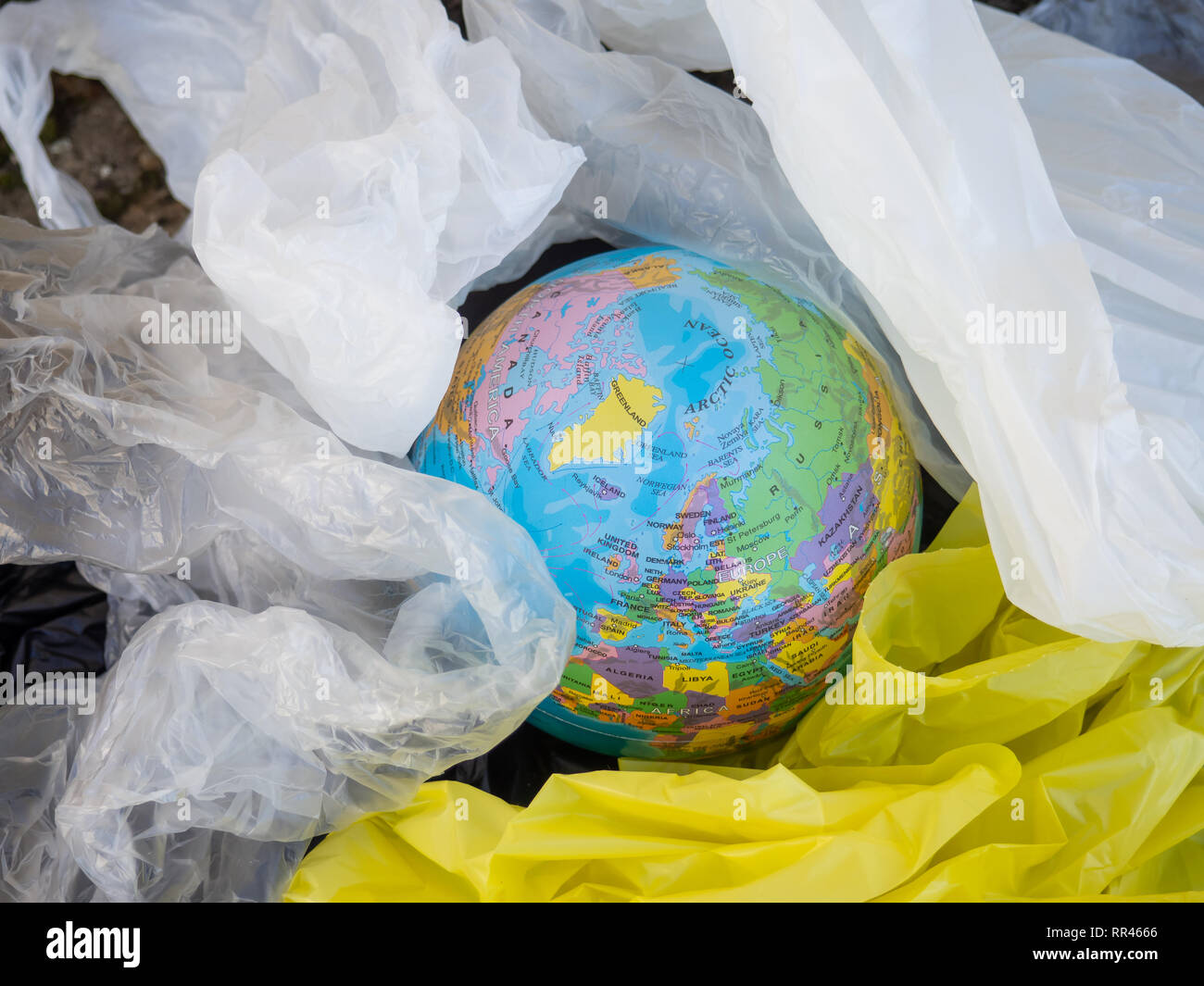 Eine Erdkugel oder Planeten Erde zwischen Müll und Plastiktüten. Konzept der Ökologie Stockfoto